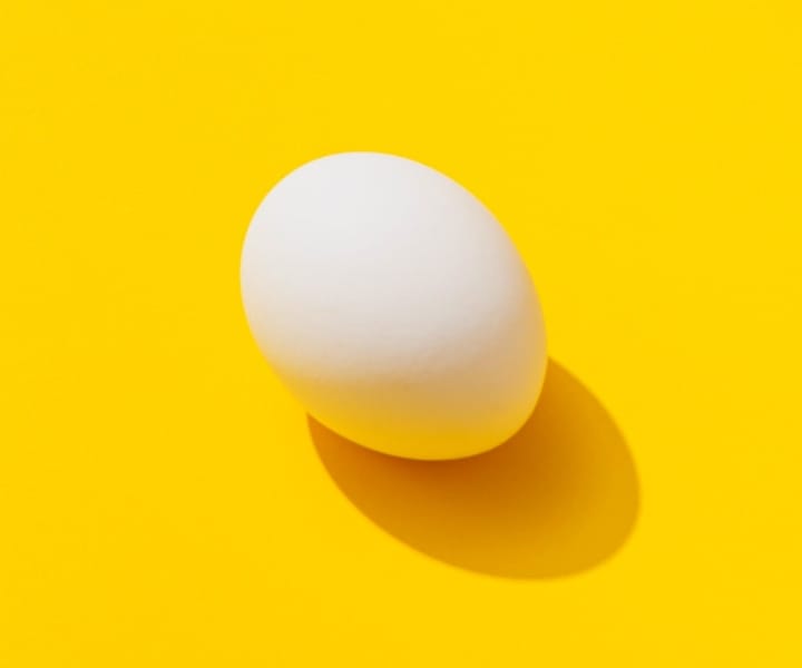 un oeuf posé sur un super jaune vif